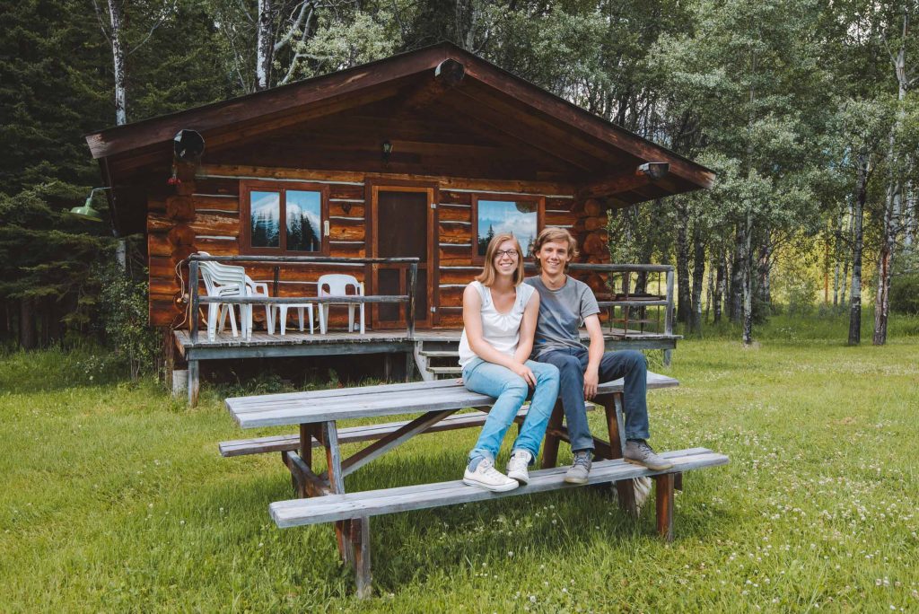 Kelly and Florian sitting in front of their canadian cabin