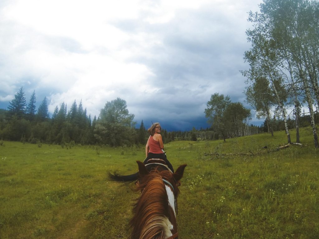 Kelly on a horse seen from the back