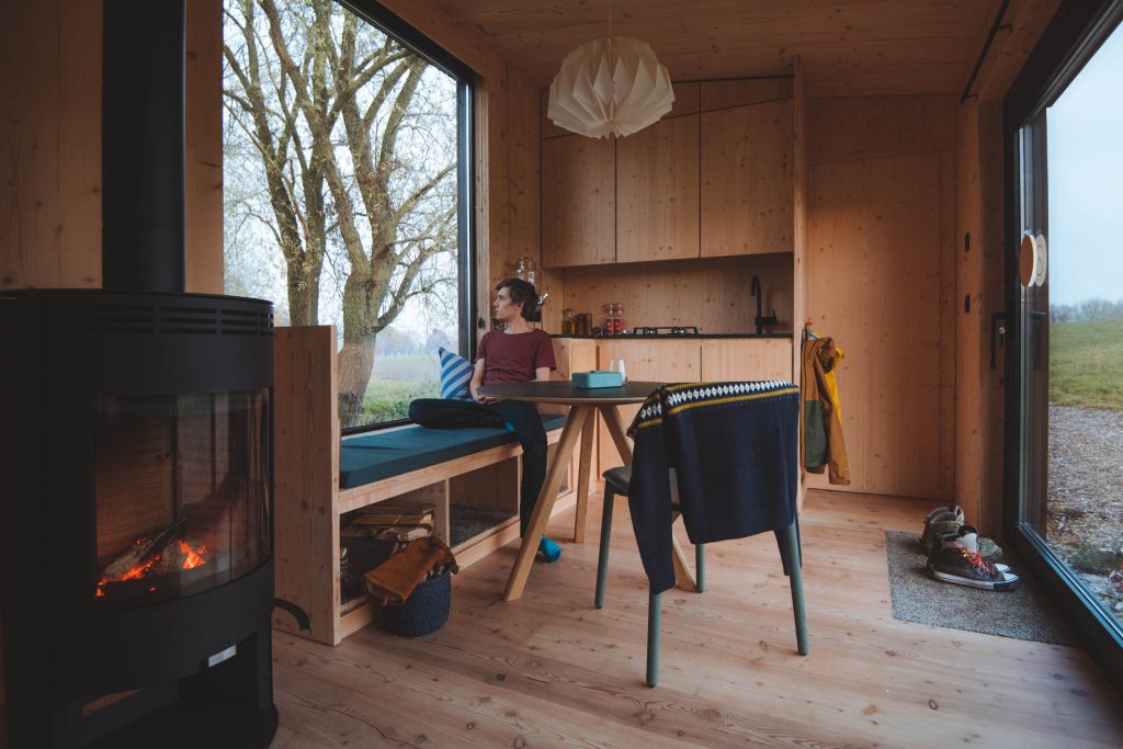 overview of the interior of the slow cabin, including the kitchen and wood-burning stove