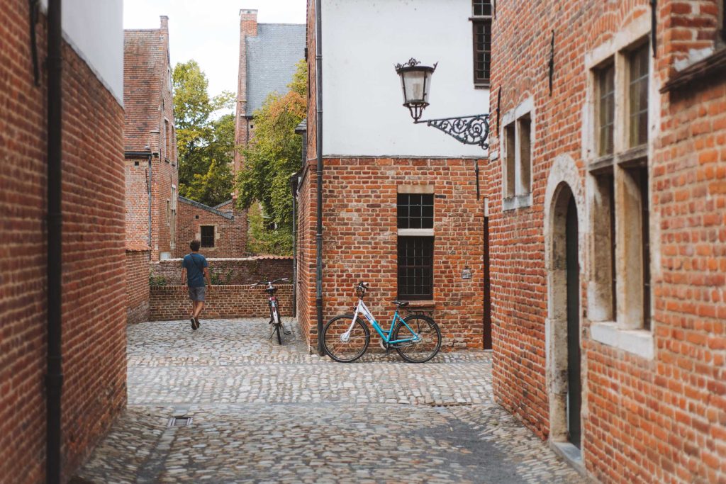 florian walking along the brick houses in the street of the great beguinage in leuven