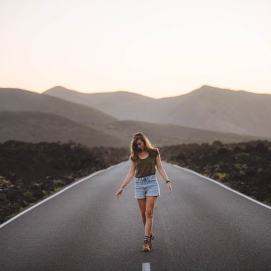 Woman in White Dress Posing on Suitcase on Dirt Road · Free Stock Photo