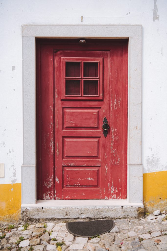 red wooden front door in the historic centre of obidos