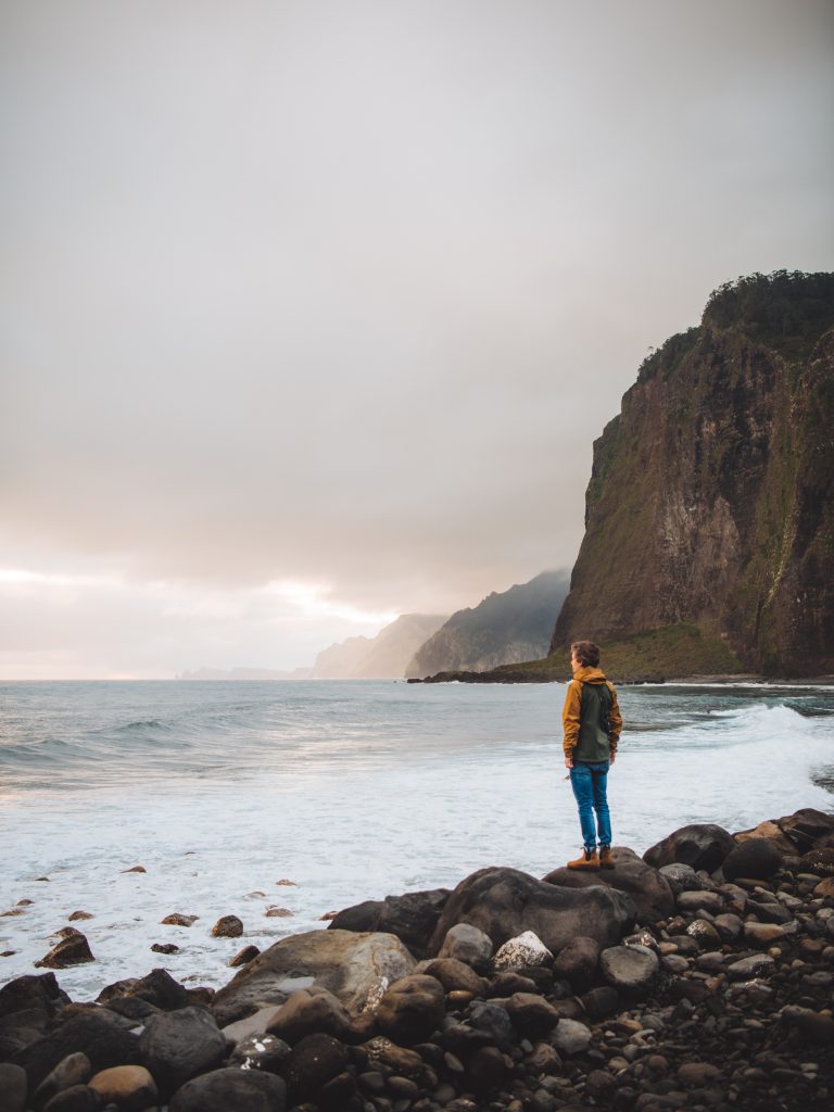 florian standing on big rocks by the ocean at Praia do Faial