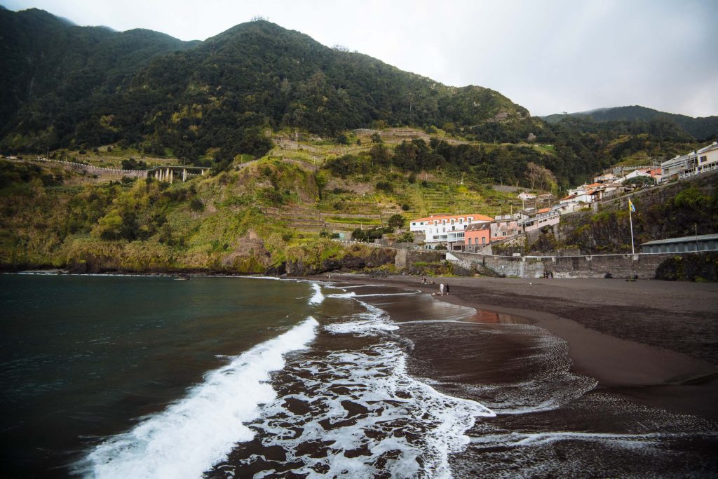 seixal beach with black sand and houses in the background