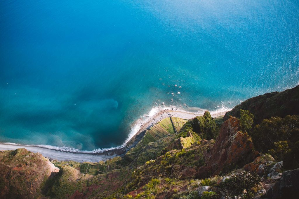 bird's eye view of the ocean and the surrounding cliffs at cabo girao in madeira