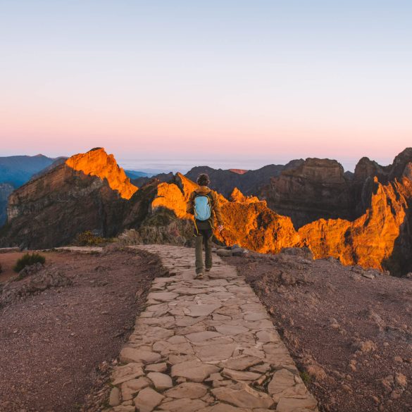 florian walking with the sun hitting the top of the mountains at pico do arieiro during sunrise