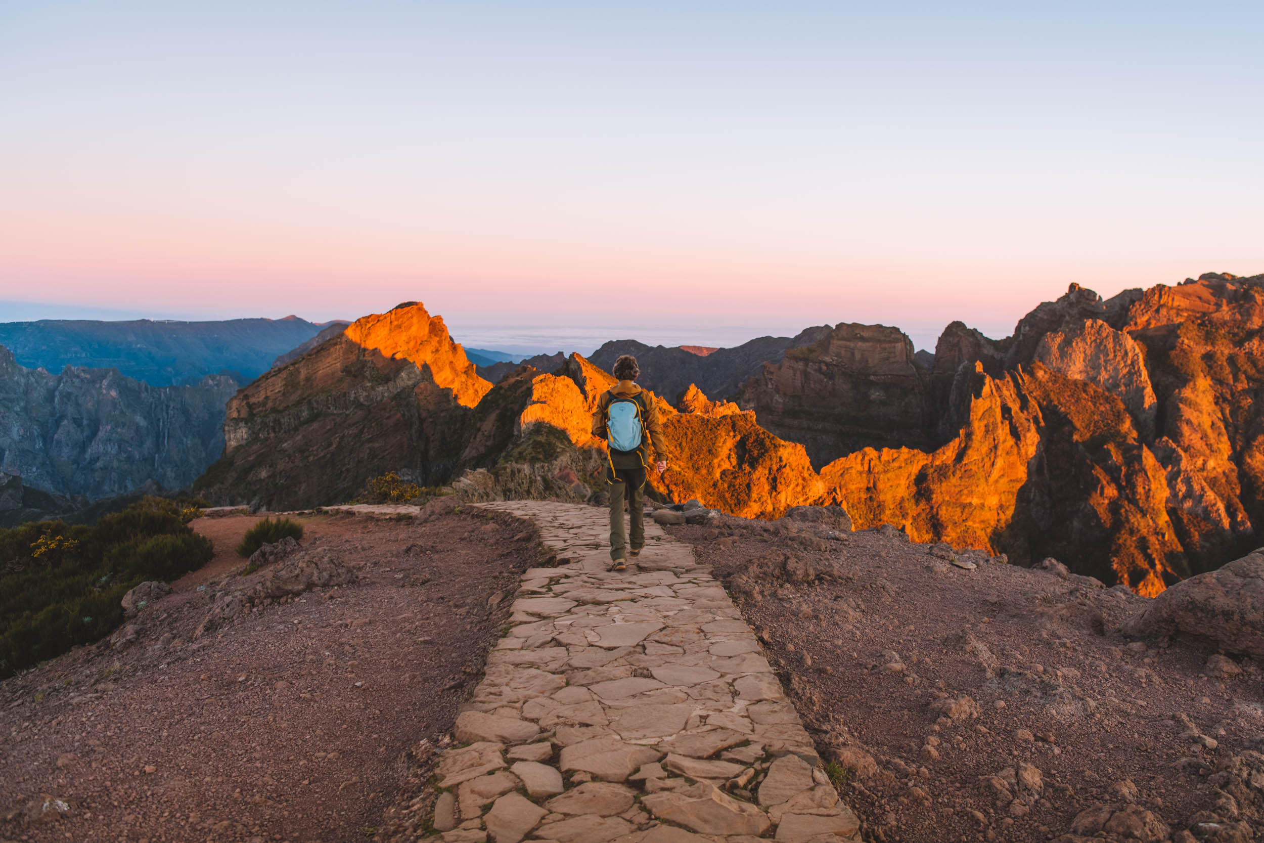 florian walking with the sun hitting the top of the mountains at pico do arieiro during sunrise