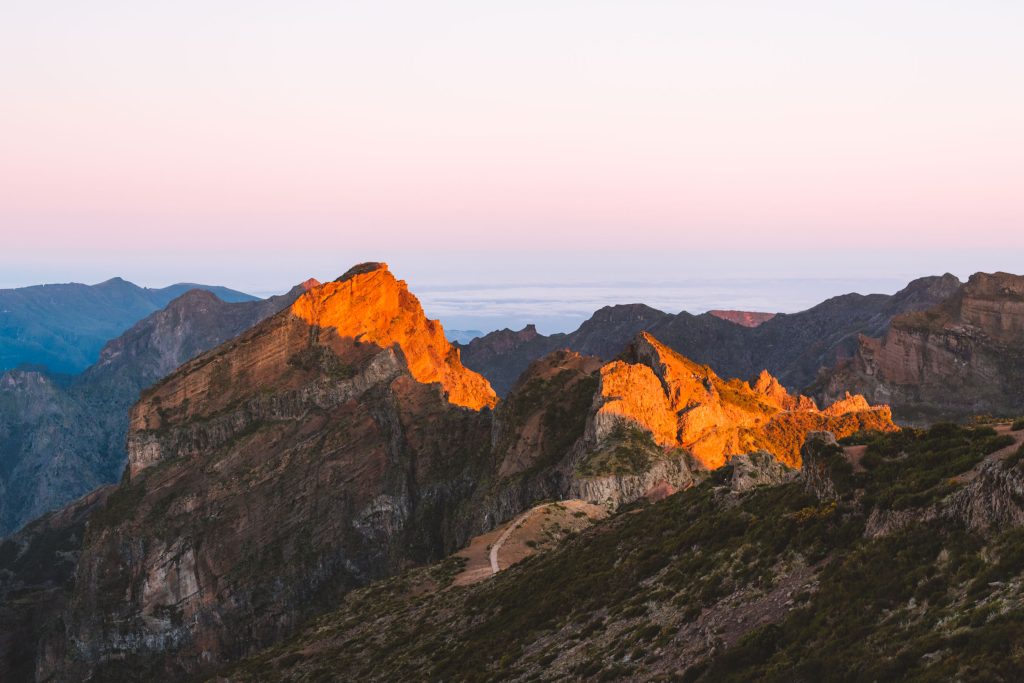 sun hitting the top of the mountains at pico do arieiro during sunrise