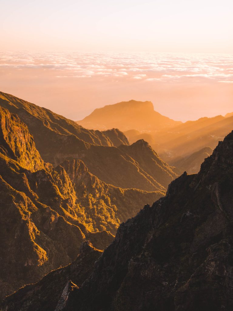 sun coming over the mountains at pico do arieiro viewpoint