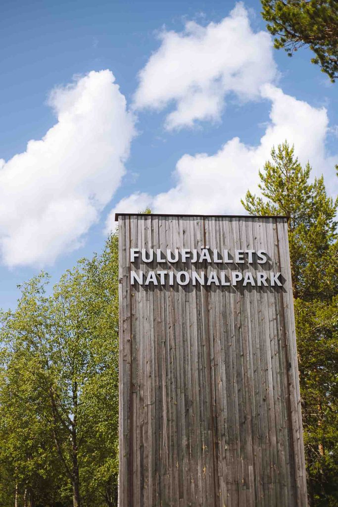 a big wooden sign at the entrance of Fulufjällets national park in sweden