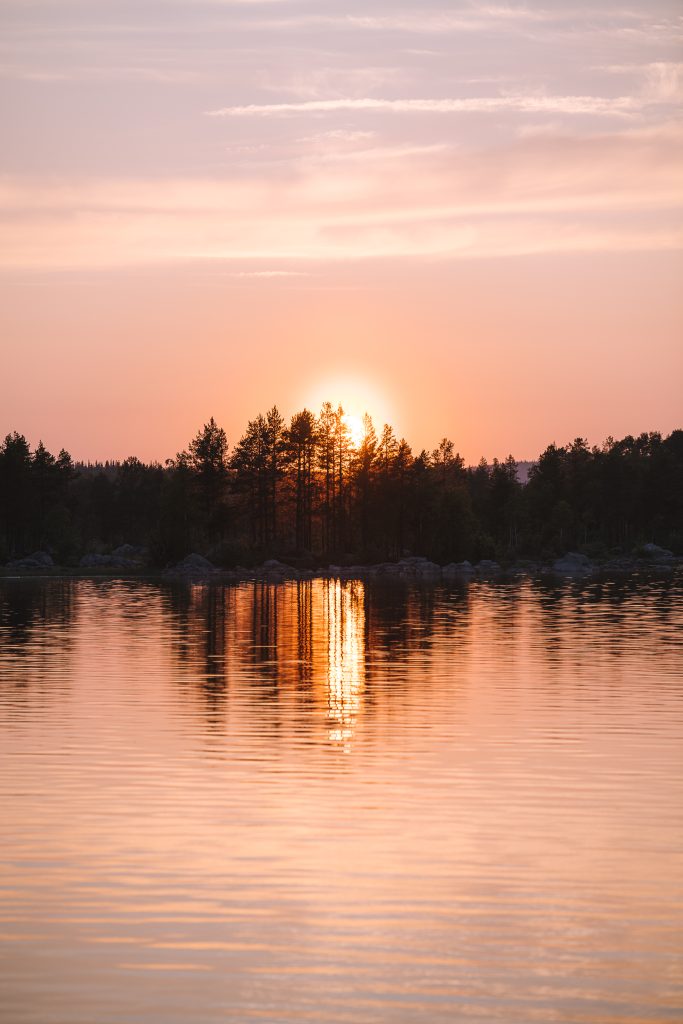 orange pink sunset reflecting in a lake in sweden